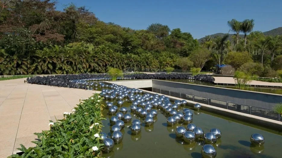 Instalação Narcissus Garden, de Yayoi Kusama, com esferas metálicas espelhadas flutuando sobre um espelho d’água no Instituto Inhotim.